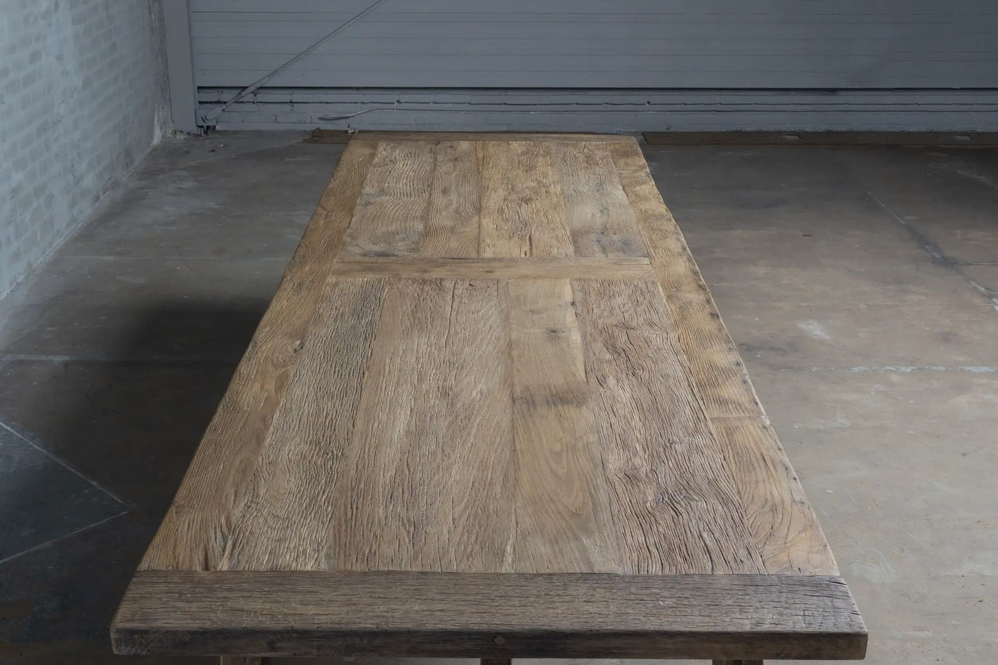 Zoom sur le plateau en bois massif d'une table de ferme ancienne