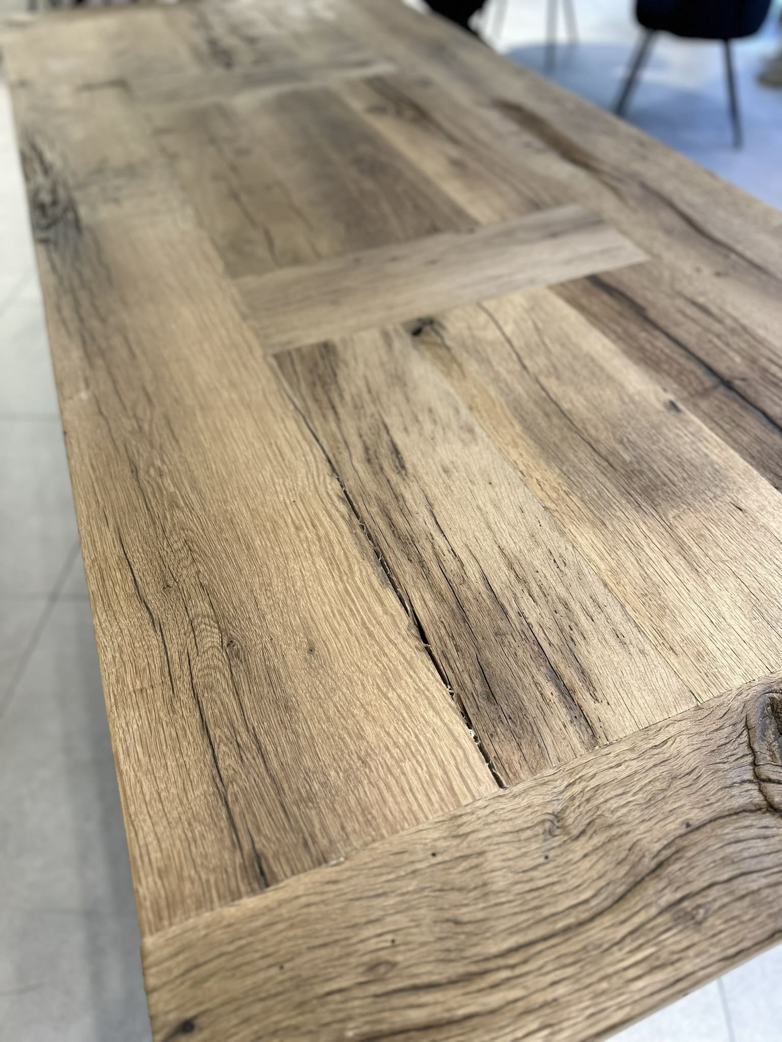 Détail du plateau en chêne massif d’une table de ferme, veinage marqué et finition naturelle.
