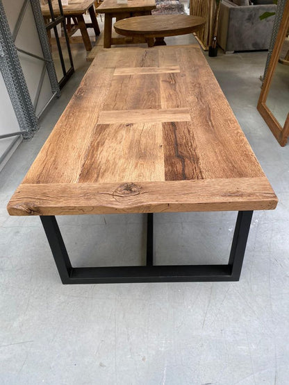 Angle d’une table de ferme en chêne massif avec pieds métal, plateau épais et teinte naturelle.