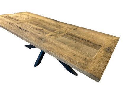 Table de ferme en chêne massif avec pieds métal exposée en showroom, finition artisanale.