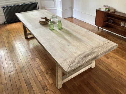 Table Founder en chêne massif ancien dans un grand salon épuré et lumineux.