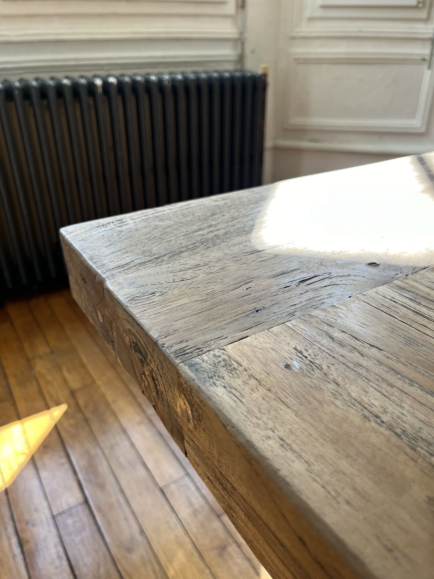 Détail de l’angle du plateau en bois massif de la table Monastère Spirito, finition brute et authentique.