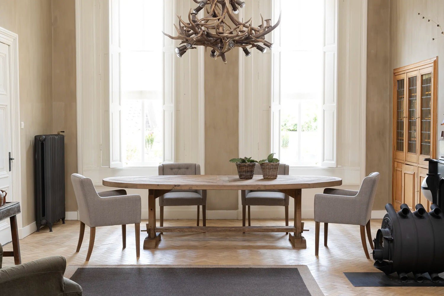 Vue d ensemble de la Table Ovale Diamant en chene ancien massif, prise en atelier, pietement central artisanal.
